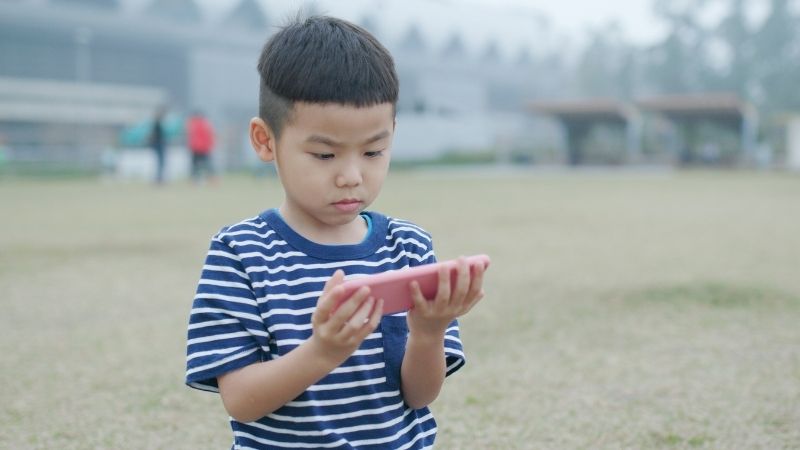 small boy watching Ukraine vs Russia war on his smart phone