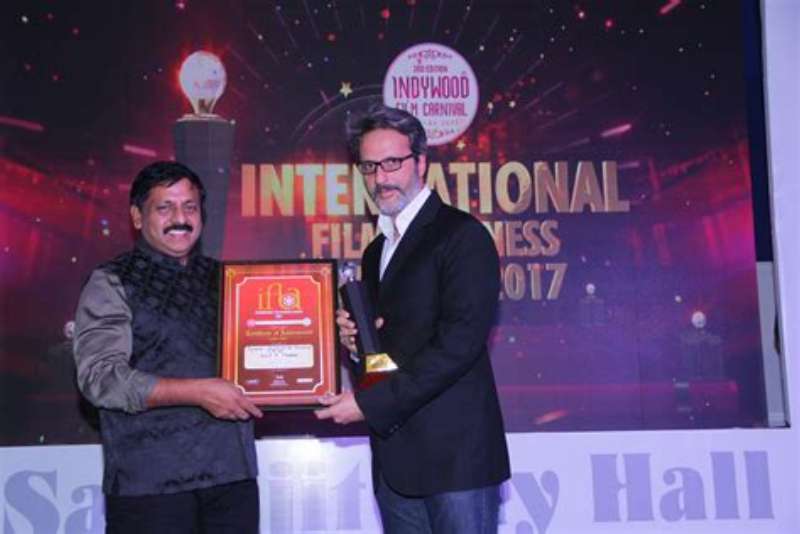 Anil Thadani holding an award, representing his remarkable contributions to film distribution.
